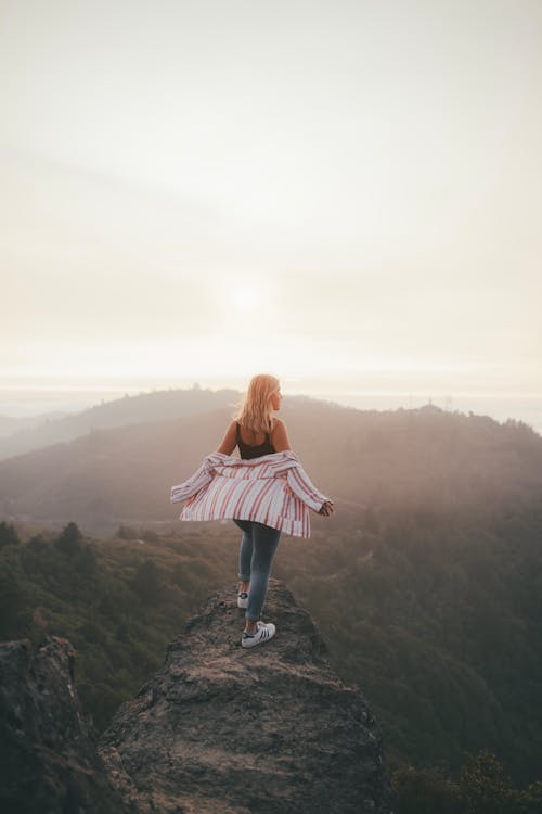 Woman Standing on the Peak of a Mountain 