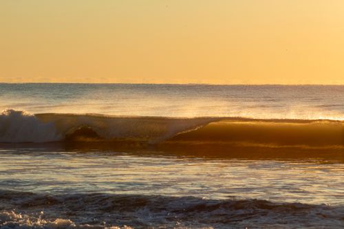 Free Serene view of ocean waves at sunset, capturing the peaceful golden hour ambiance. Stock Photo