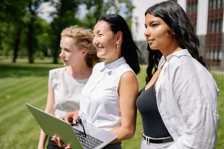 Women Standing Outdoors Holding A Laptop