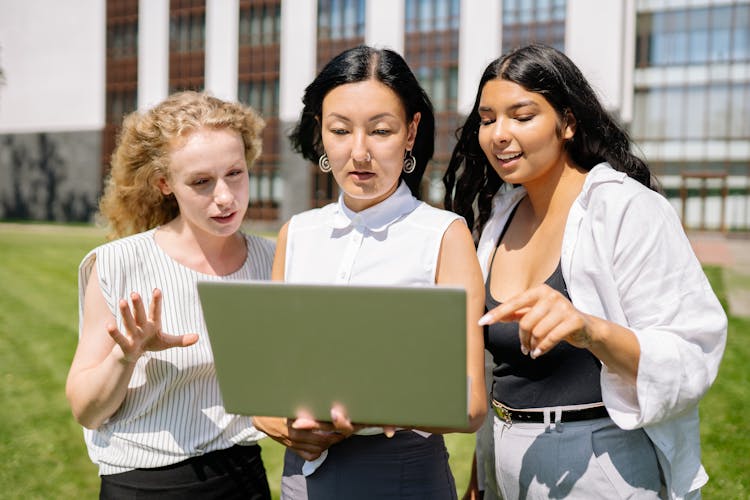 Women Looking At A Laptop While Outside The Office