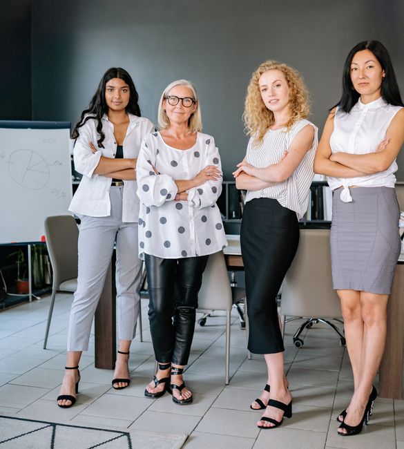 Photo by Yan Krukau Confident and diverse businesswomen standing in modern office, arms crossed.