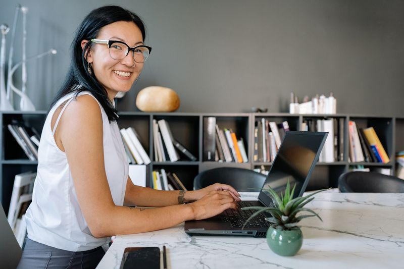 Professionnelle souriante travaillant sur son ordinateur portable dans un bureau moderne