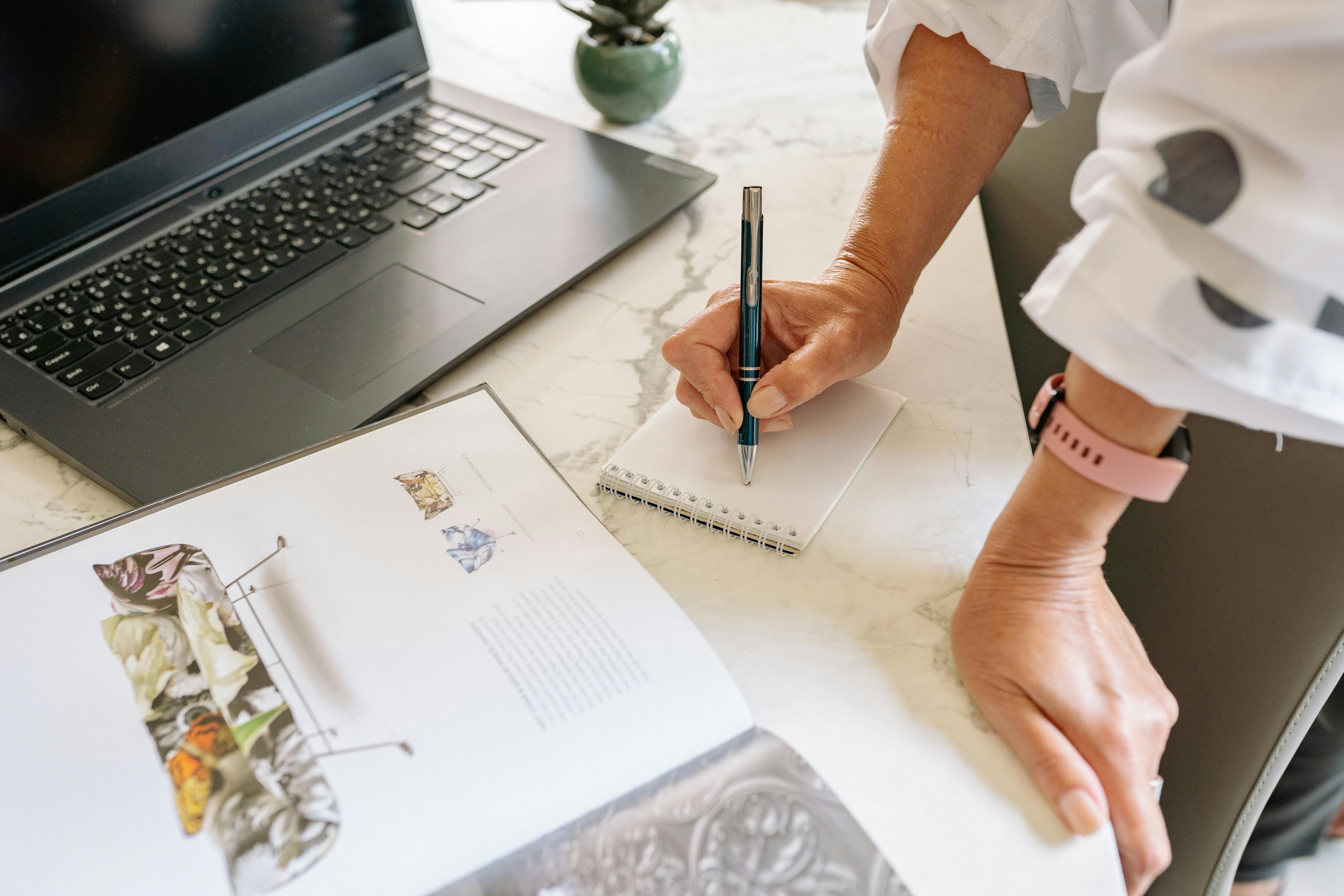 Person Writing on a Notepad with a Pen · Free Stock Photo