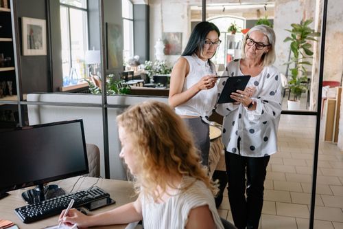 Free Professional women collaborating in a stylish office environment with tablets and computers. Stock Photo
