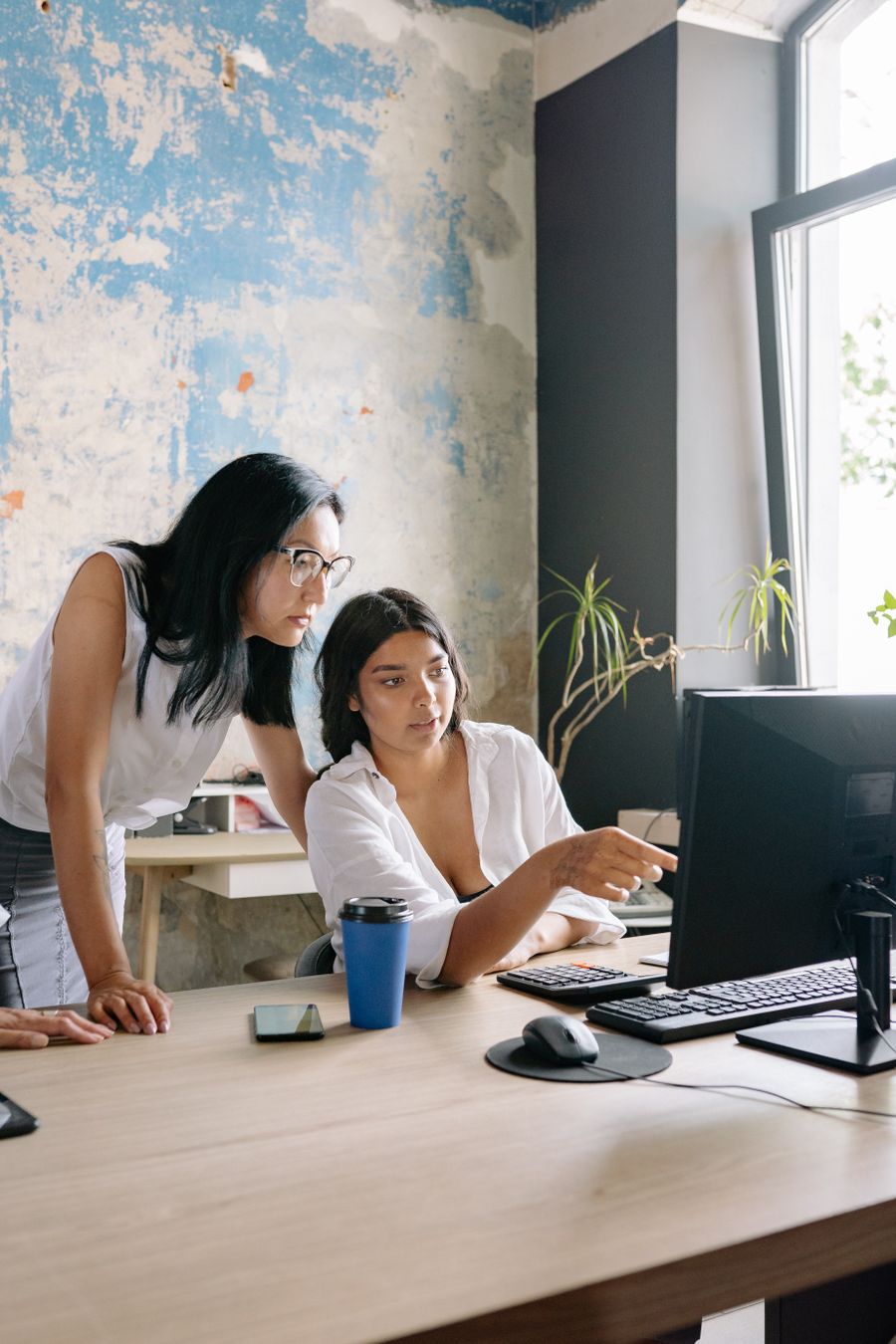 Two professional colleagues reviewing data together at a workstation