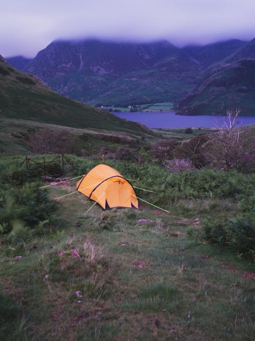 Yellow Tent in a Mountain Valley Near a River 