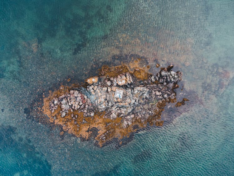 Drone Shot Of A Little Rocky Island Emerging From Water 