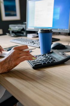 Businesswoman handling finance or calculation tasks with a calculator on her desk.