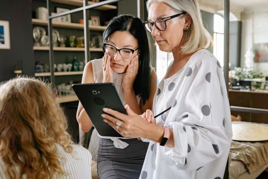 mature retail worker learning digital technology tablet
