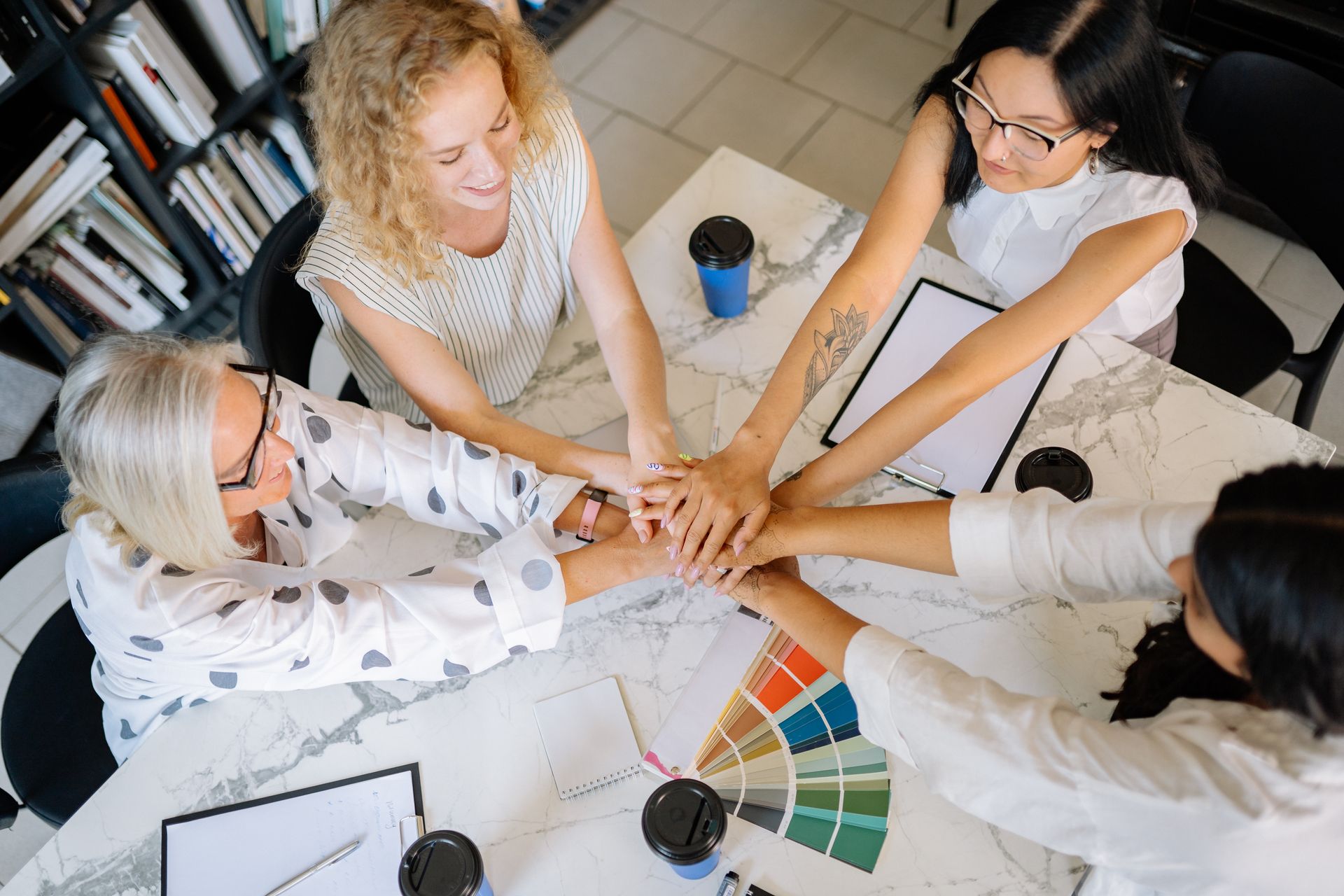 Hands Together of Women Sitting at Marbled Table