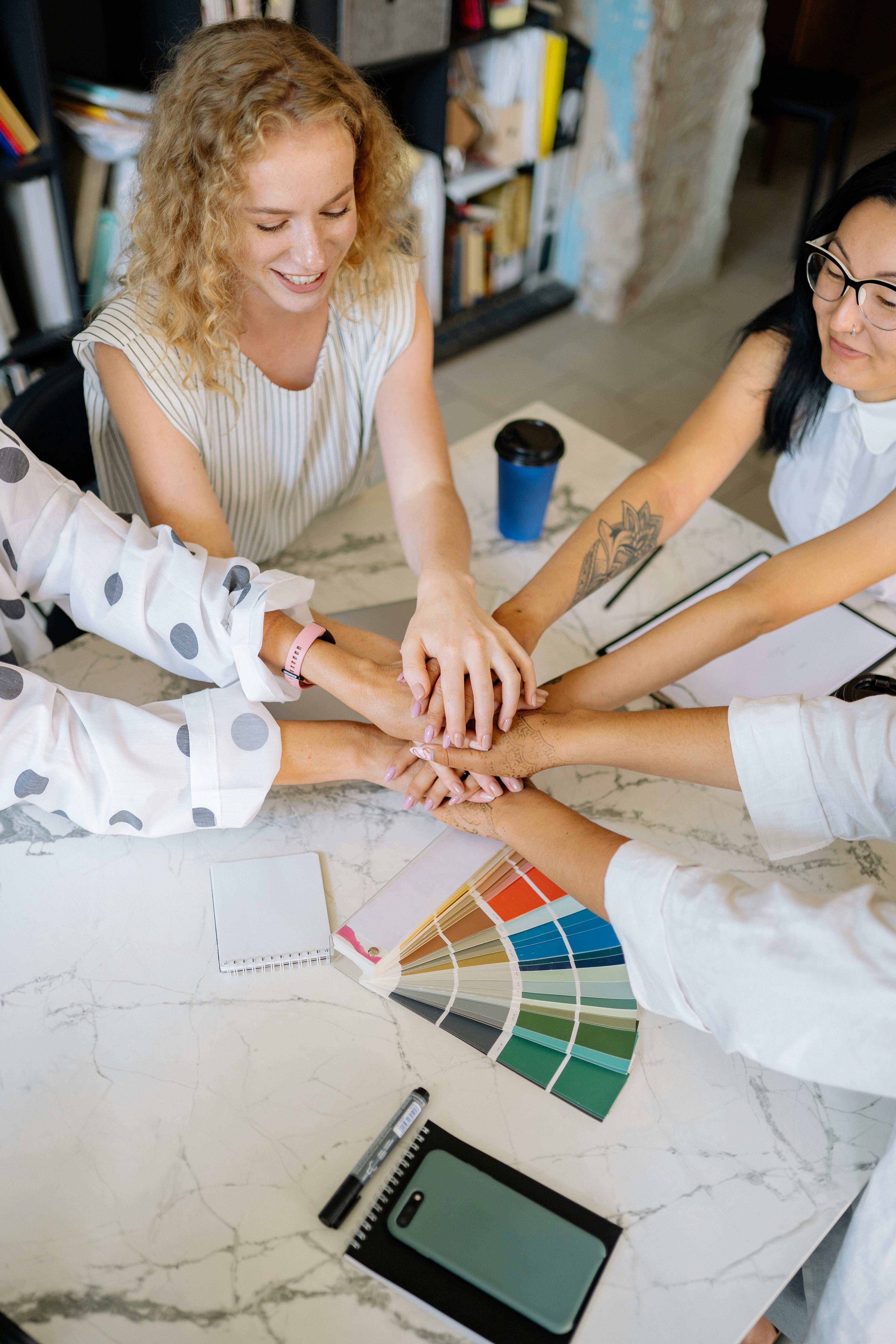 hands together of women sitting at table in the office