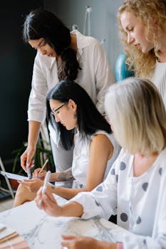 A group of diverse women brainstorming and collaborating in a modern office space.
