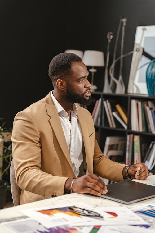 A Man in Brown Suit Sitting on a Chair