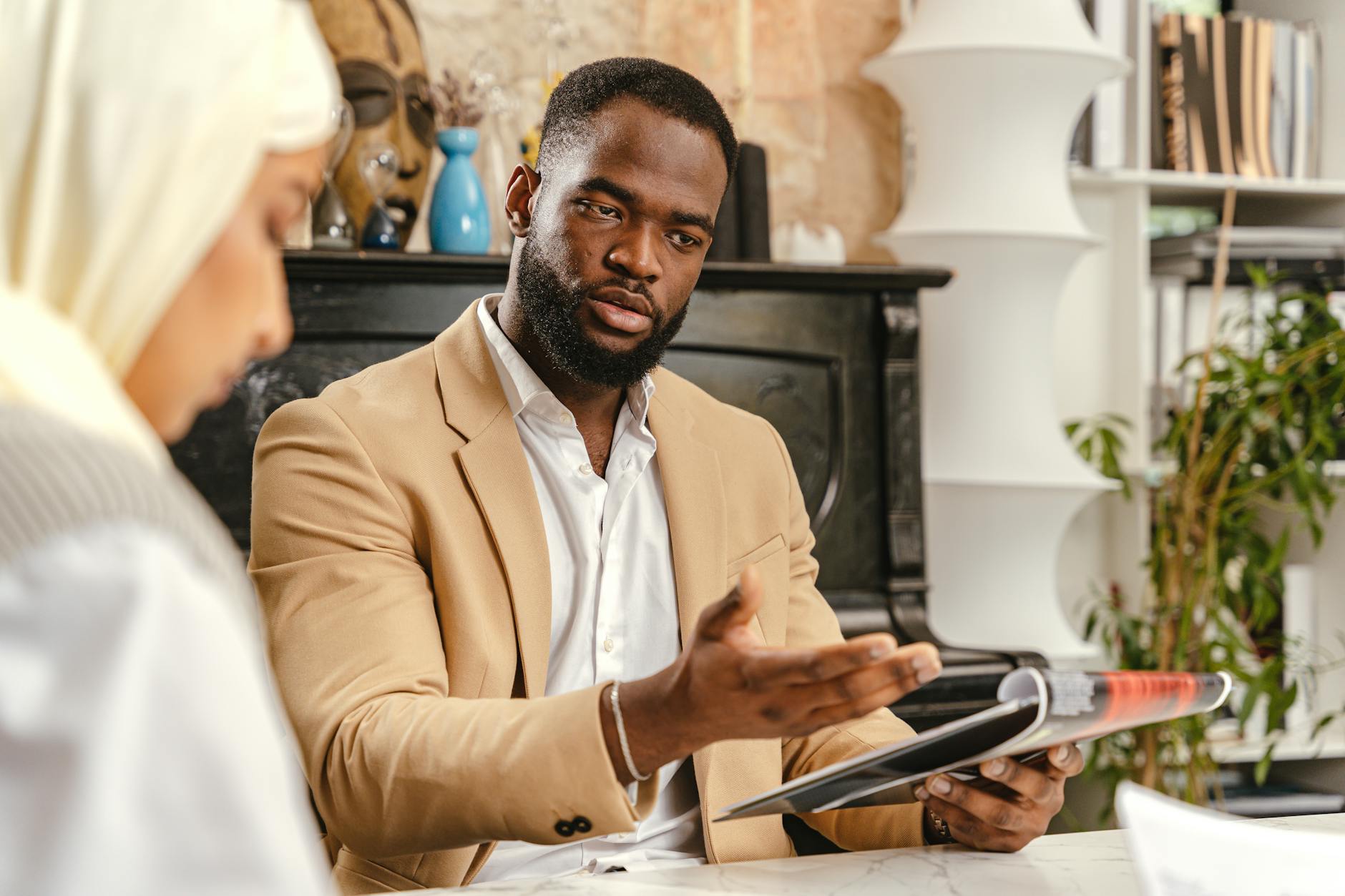 Professionals in a discussion during a business meeting with documents in hand.