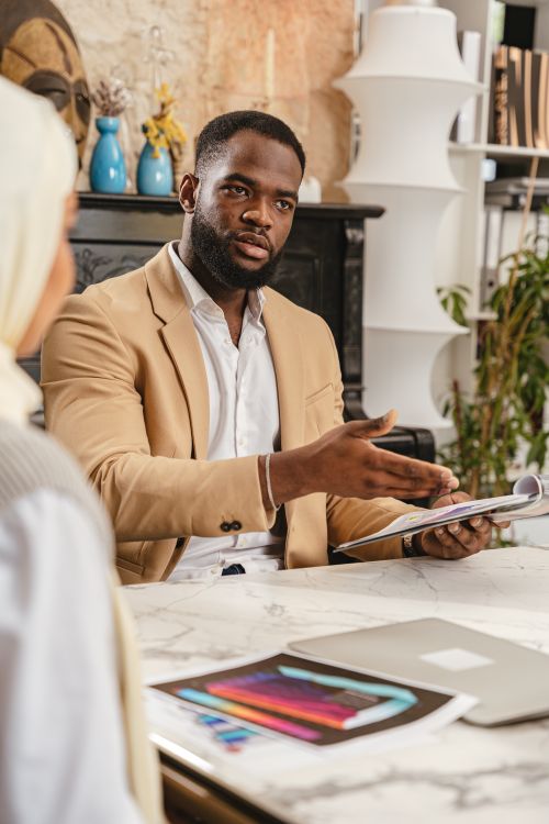 Free Diverse team in a business meeting discussing documents at a modern office desk. Stock Photo