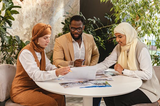 Diverse professionals engaged in a collaborative meeting around a table, discussing documents.