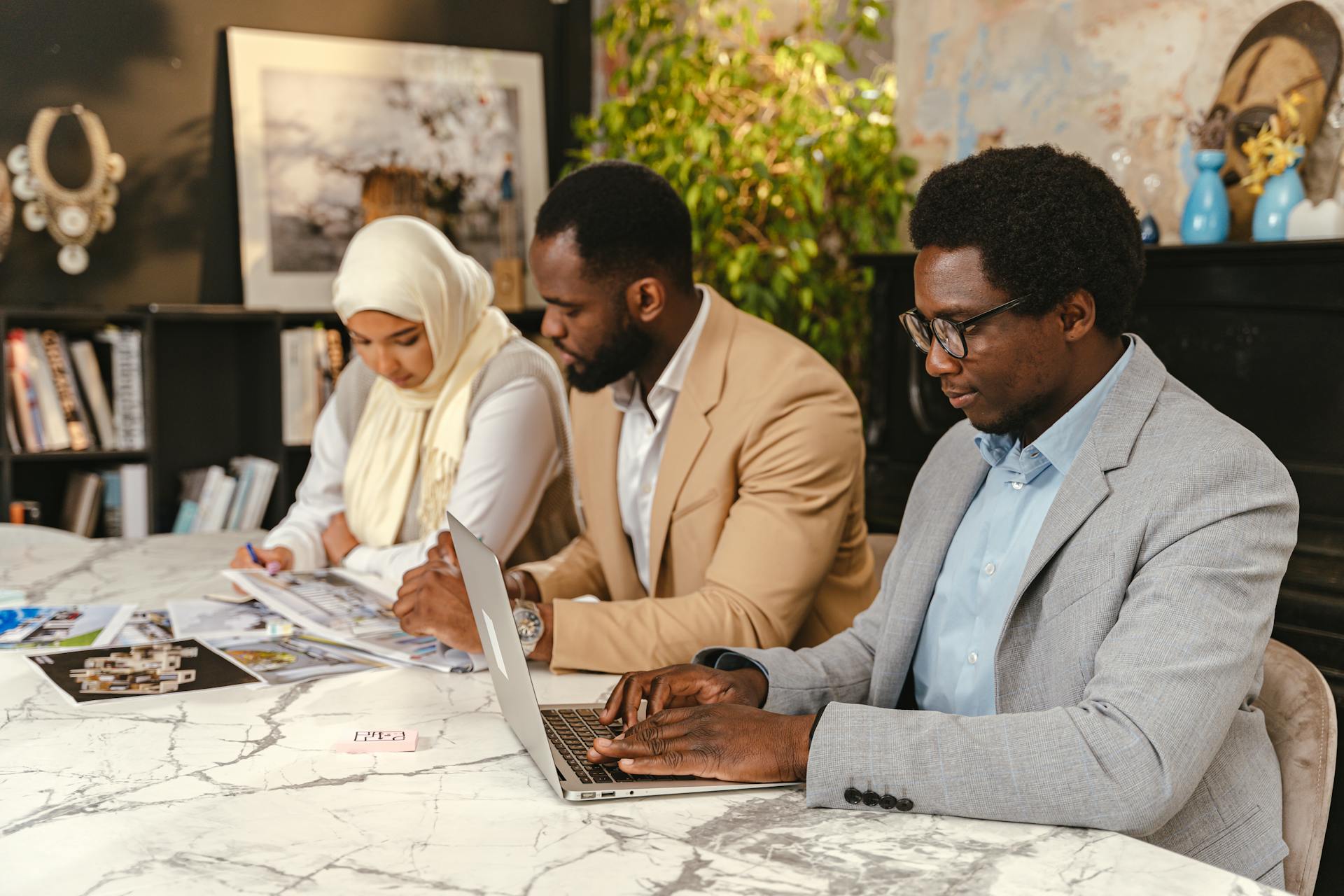 A diverse team discusses ideas at a marble table, brainstorming and planning in an office setting.