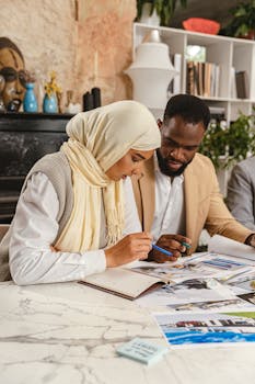 African American man and Arabic woman collaborating on projects at a desk in a cozy indoor setting.