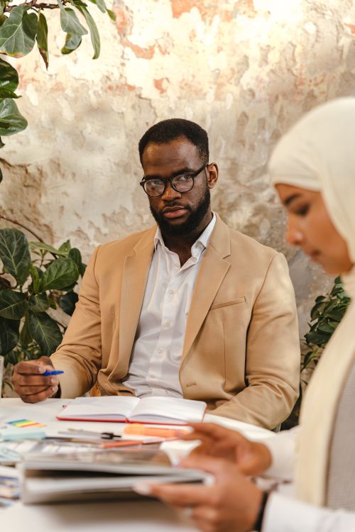 Free A business meeting with diverse professionals collaborating on projects at a table. Stock Photo