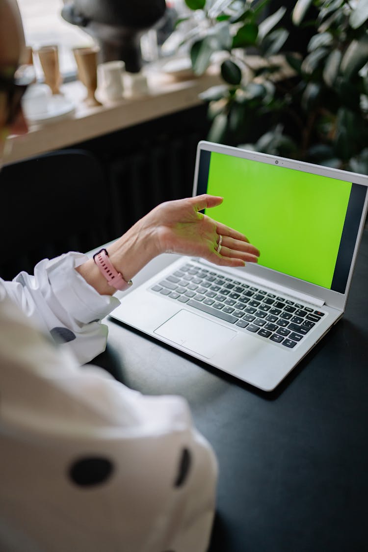 Person Pointing Her Hand Near The Laptop Screen 