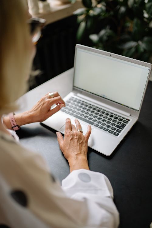 Free Businesswoman working on a laptop in a modern office environment. Stock Photo