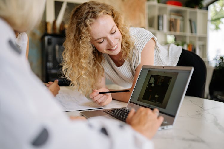 Curly Haired Woman Looking At The Laptop Screen 