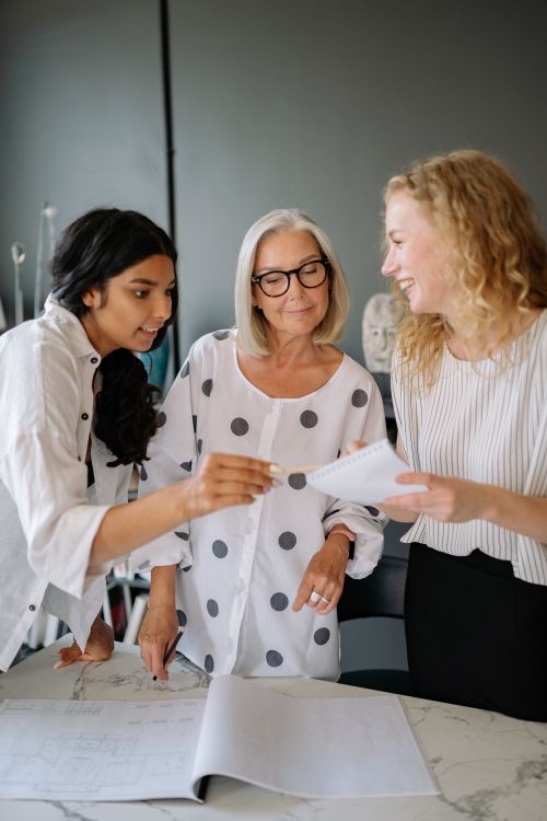 Free Three women of different ages working together in an office, reviewing documents. Stock Photo