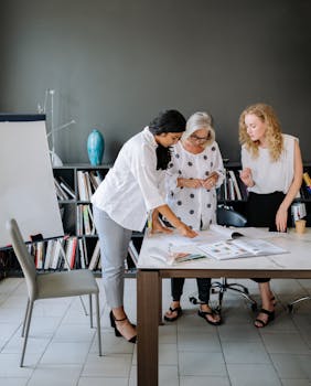 Three businesswomen engaged in a brainstorming session in a modern office environment.