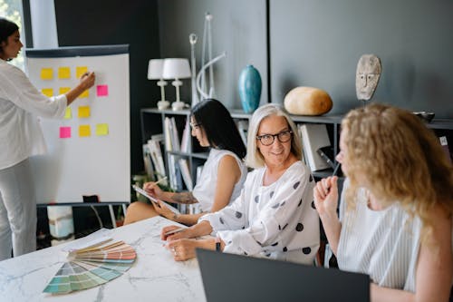 Free Women Sitting at the Meeting Table While Having a Discussion Stock Photo