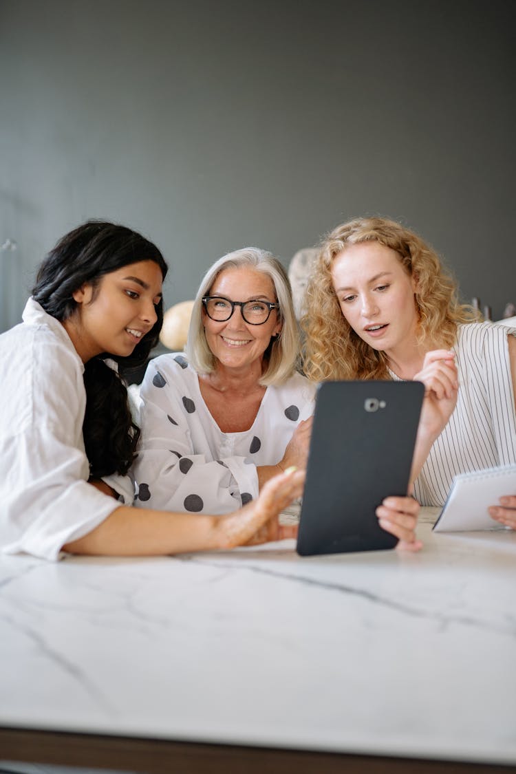 Group Of Women In An Office Looking At A Tablet 