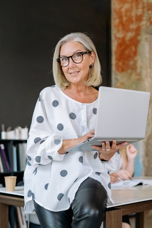 Woman Wearing Eyeglasses Holding a Laptop
