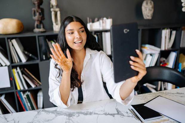 Person waving during a video call at a desk, photo by Yan Krukau on Pexels