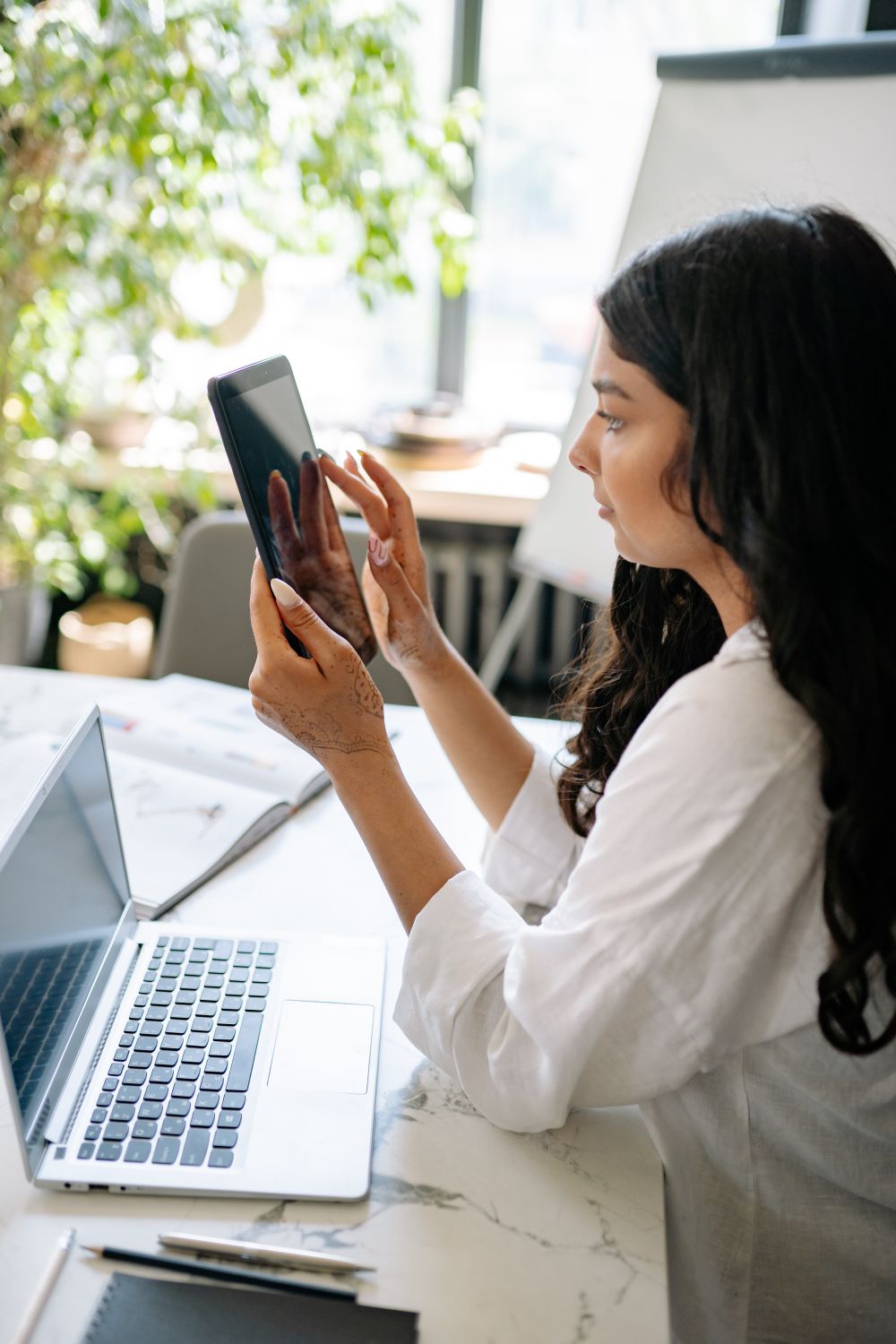 Indian marketer reviewing campaign data on a tablet and laptop