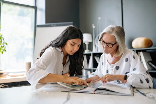 Two women engaged in a collaborative meeting at an office, emphasizing diversity and teamwork.