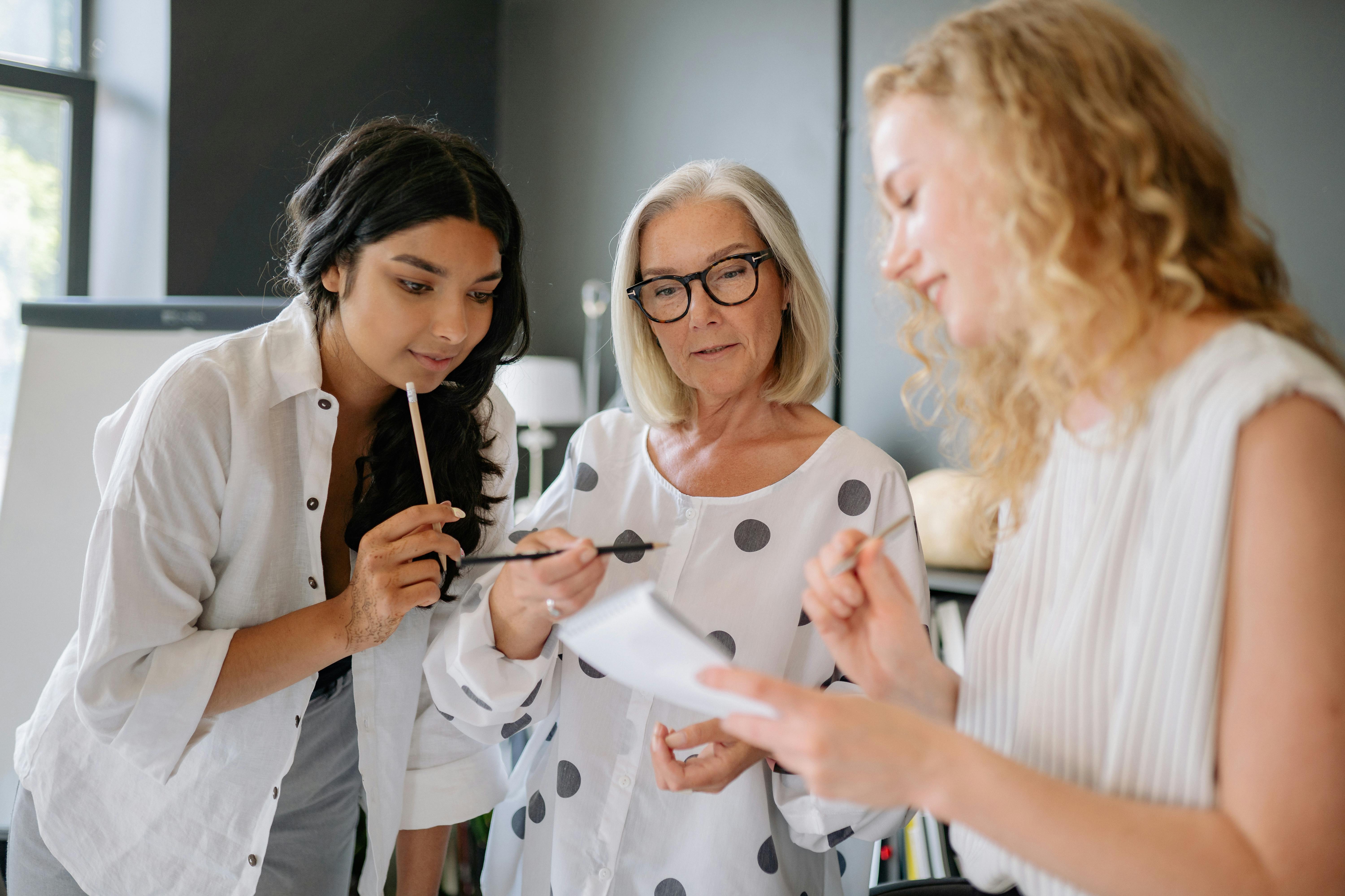 A diverse team of women engaged in a productive office meeting, working together with focus and dedication.