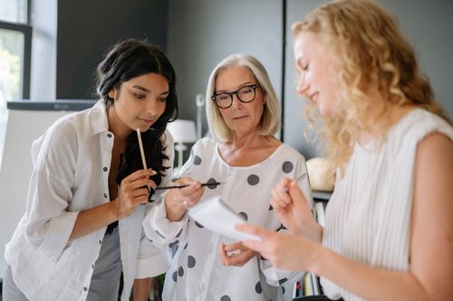 Free A diverse team of women engaged in a productive office meeting, working together with focus and dedication. Stock Photo