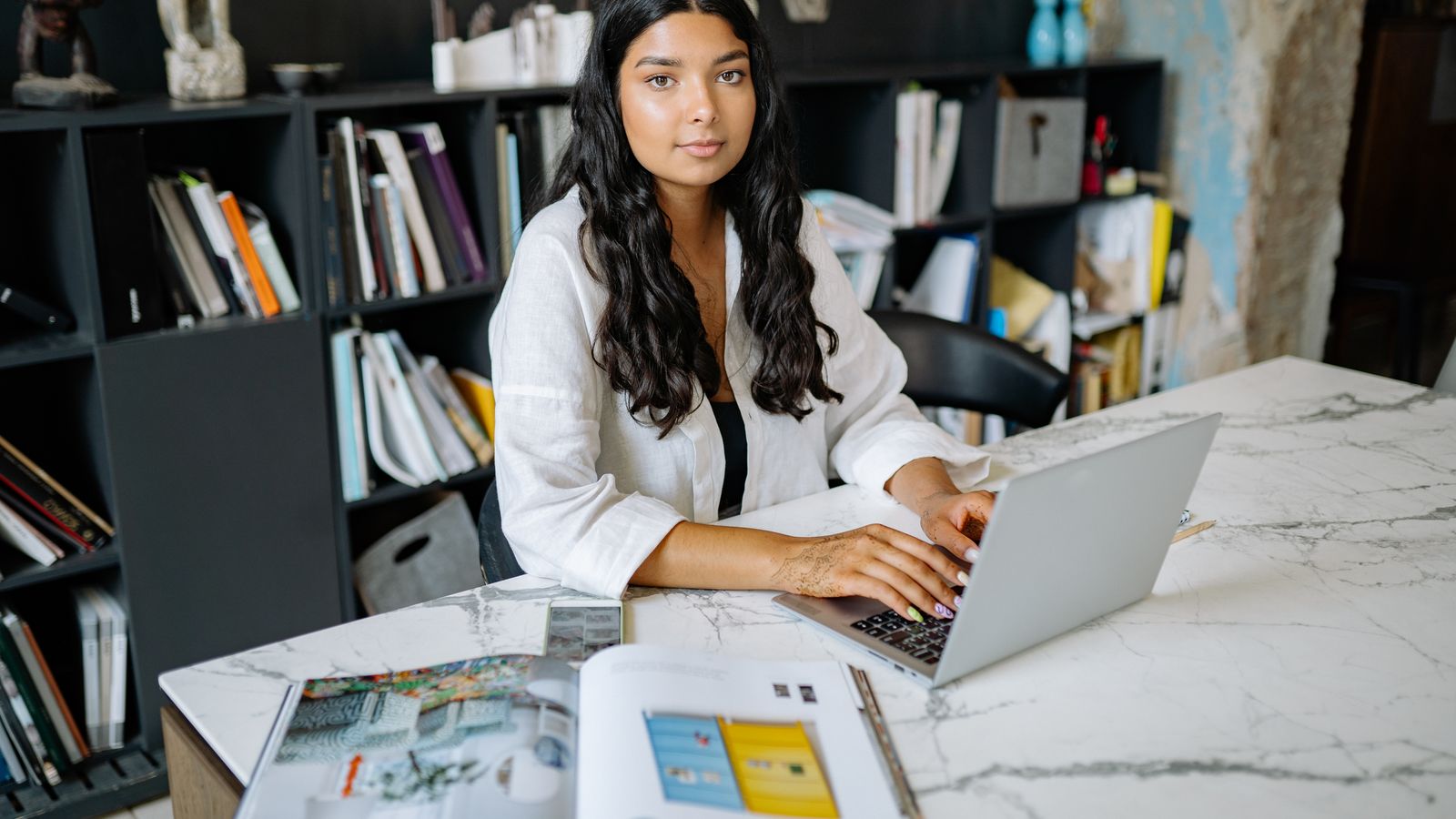 A product professional working from a minimalist marble office desk