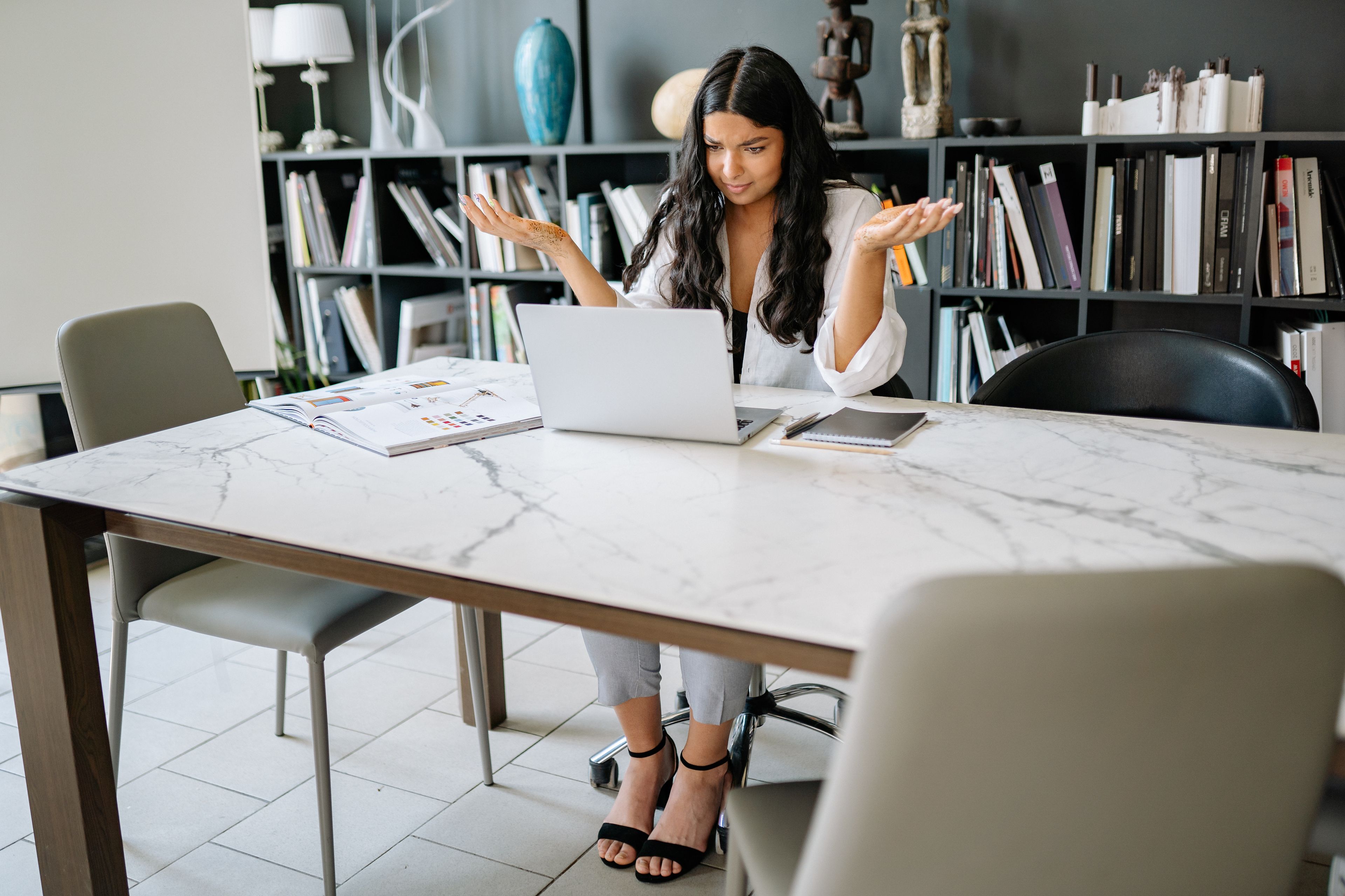 Job seeker at a home desk reviewing a resume score report on a laptop screen with notes beside it