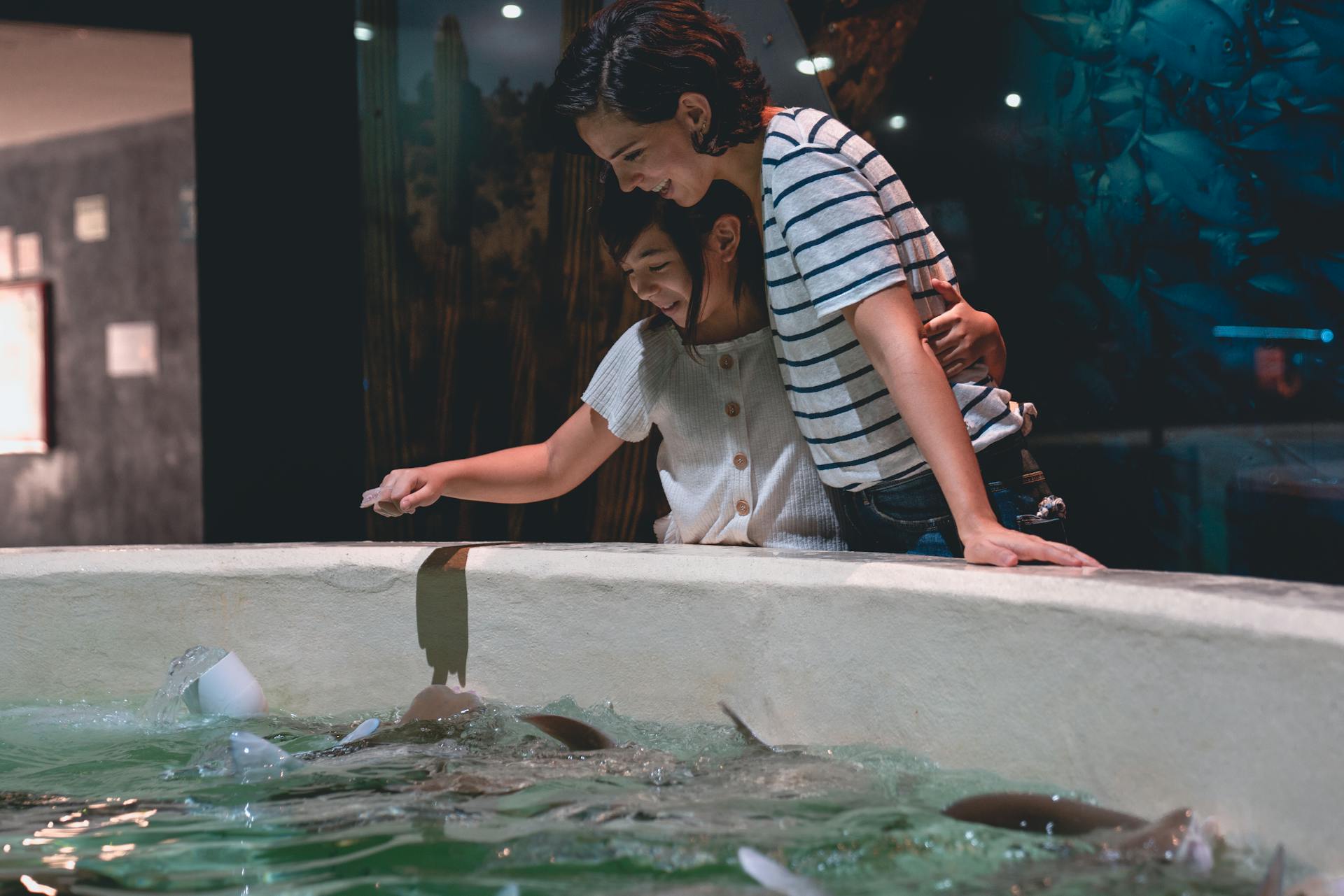 A Child and a Woman Looking at Marine Animals
