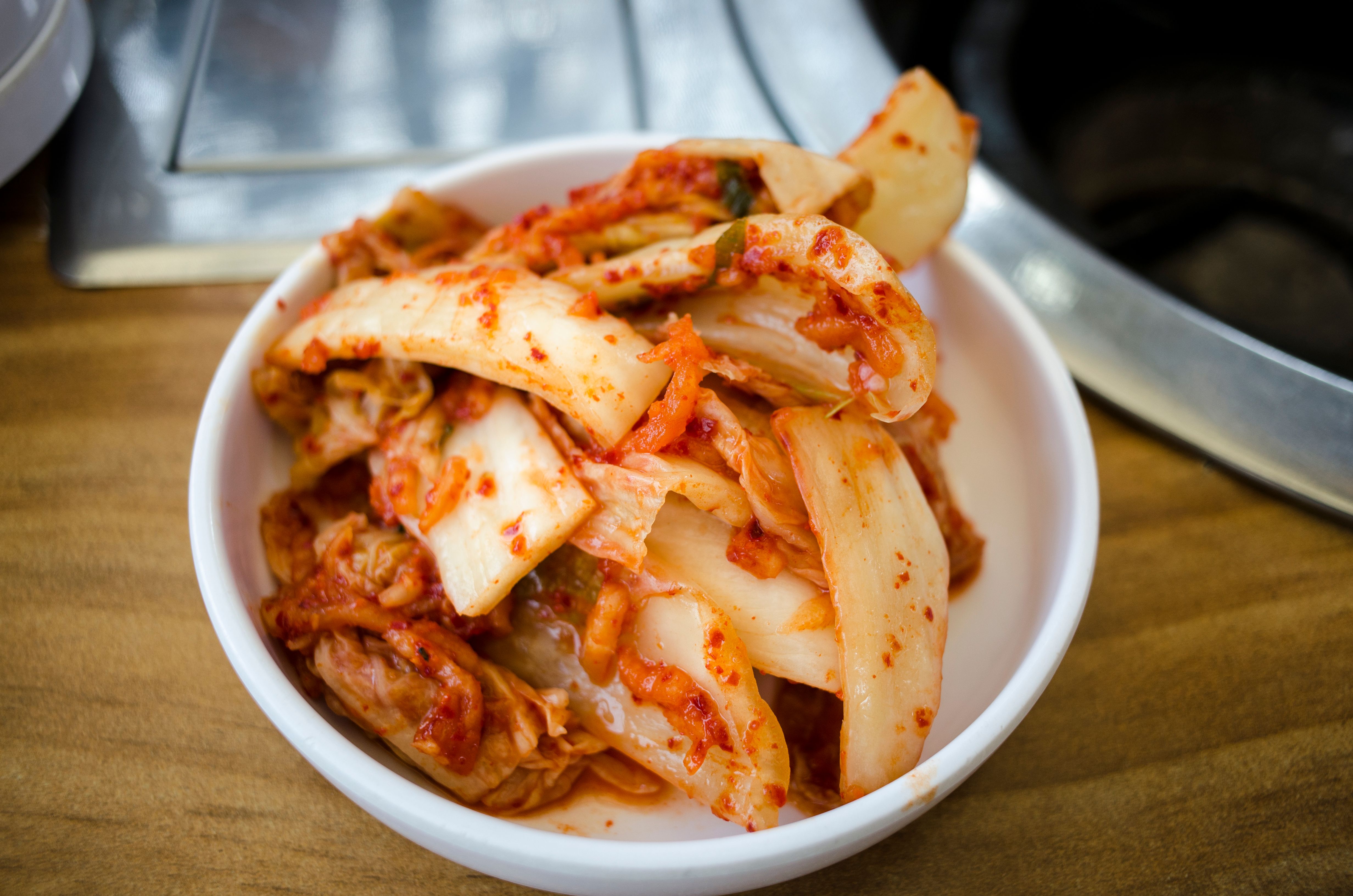 Close-up of spicy Korean kimchi in a white ceramic bowl, perfect for food enthusiasts.