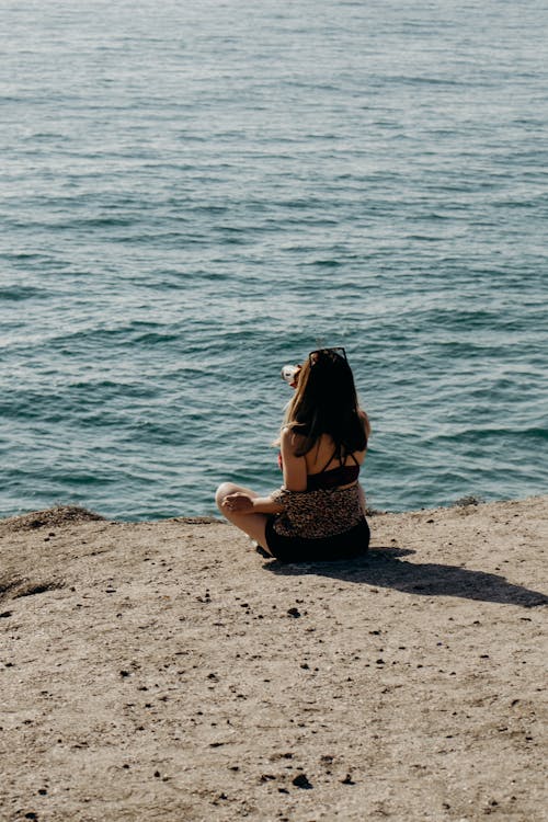 Woman Sitting on Beach Shore