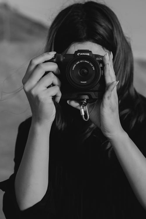 Grayscale Photo of Woman Holding Black Camera