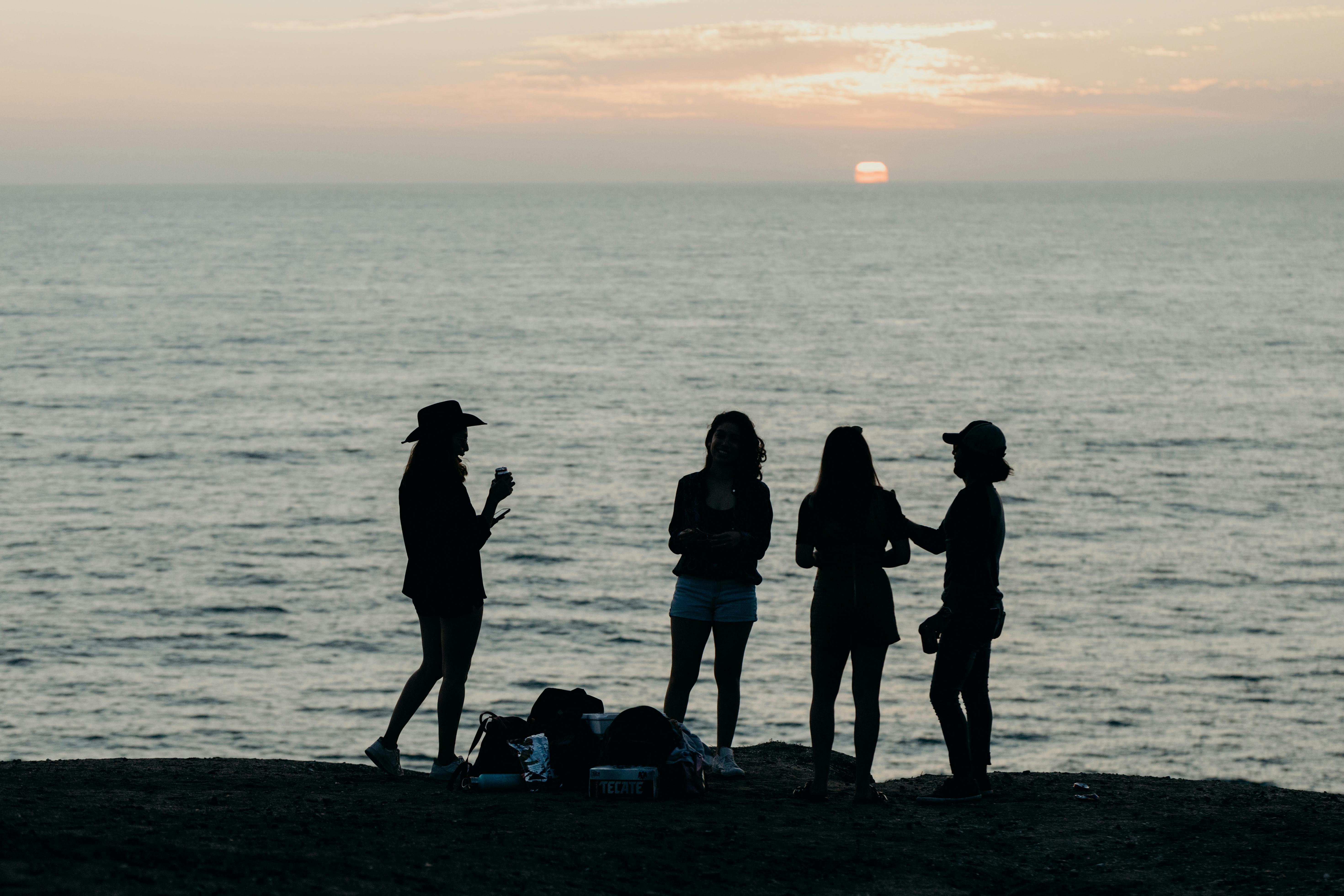 Two Women With Man Hugging by the Sea · Free Stock Photo