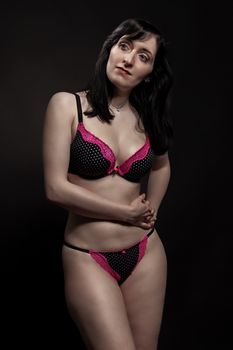 Captivating studio portrait of a woman posing in stylish lingerie, showcasing elegance and confidence.