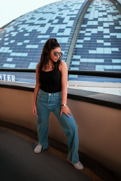 Woman in Black Top and Blue Denim Jeans