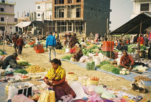 Bustling outdoor market scene with vendors selling various produce in an urban setting.