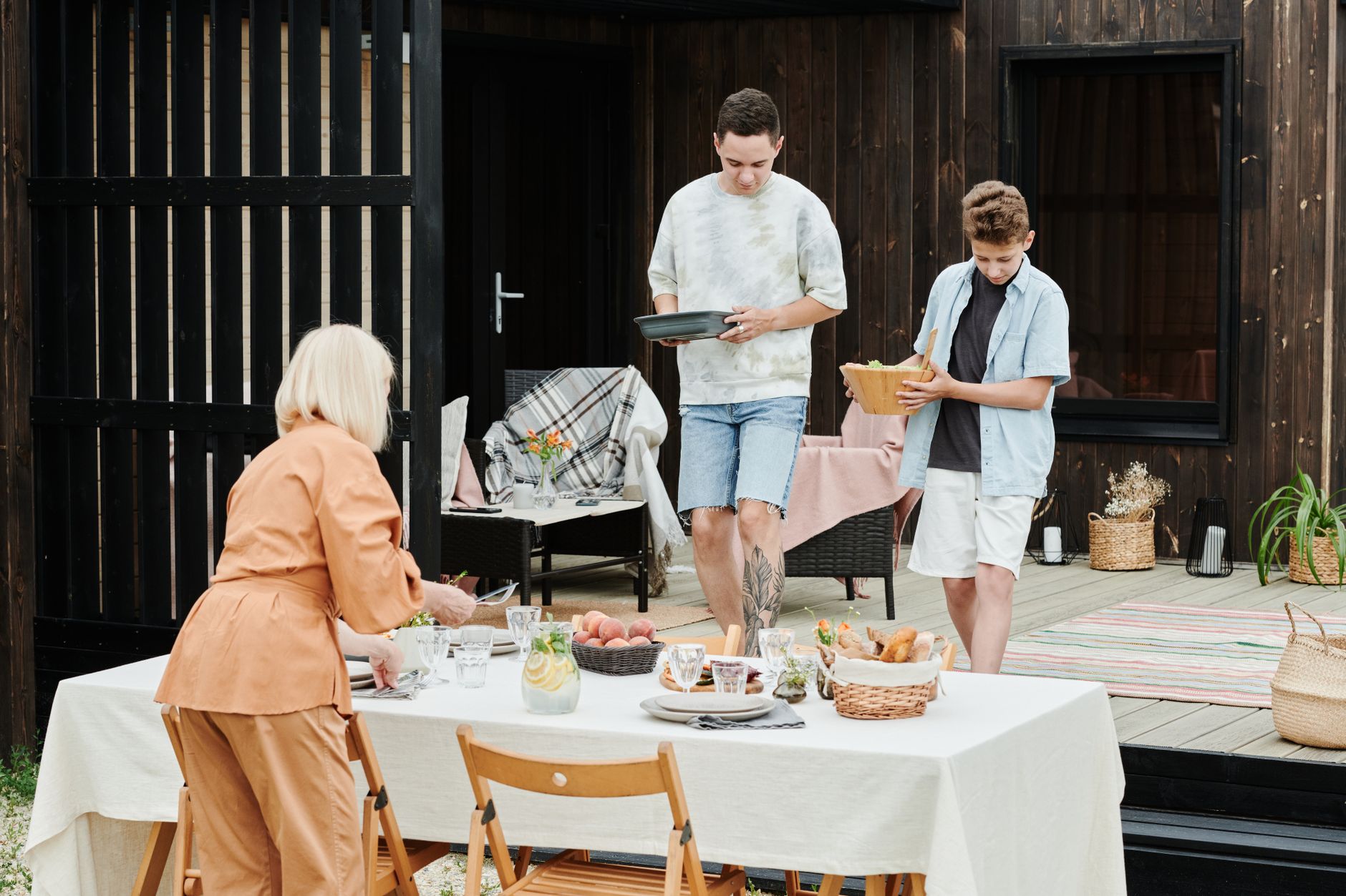 Family members setting up an outdoor table for lunch, creating a cozy atmosphere.