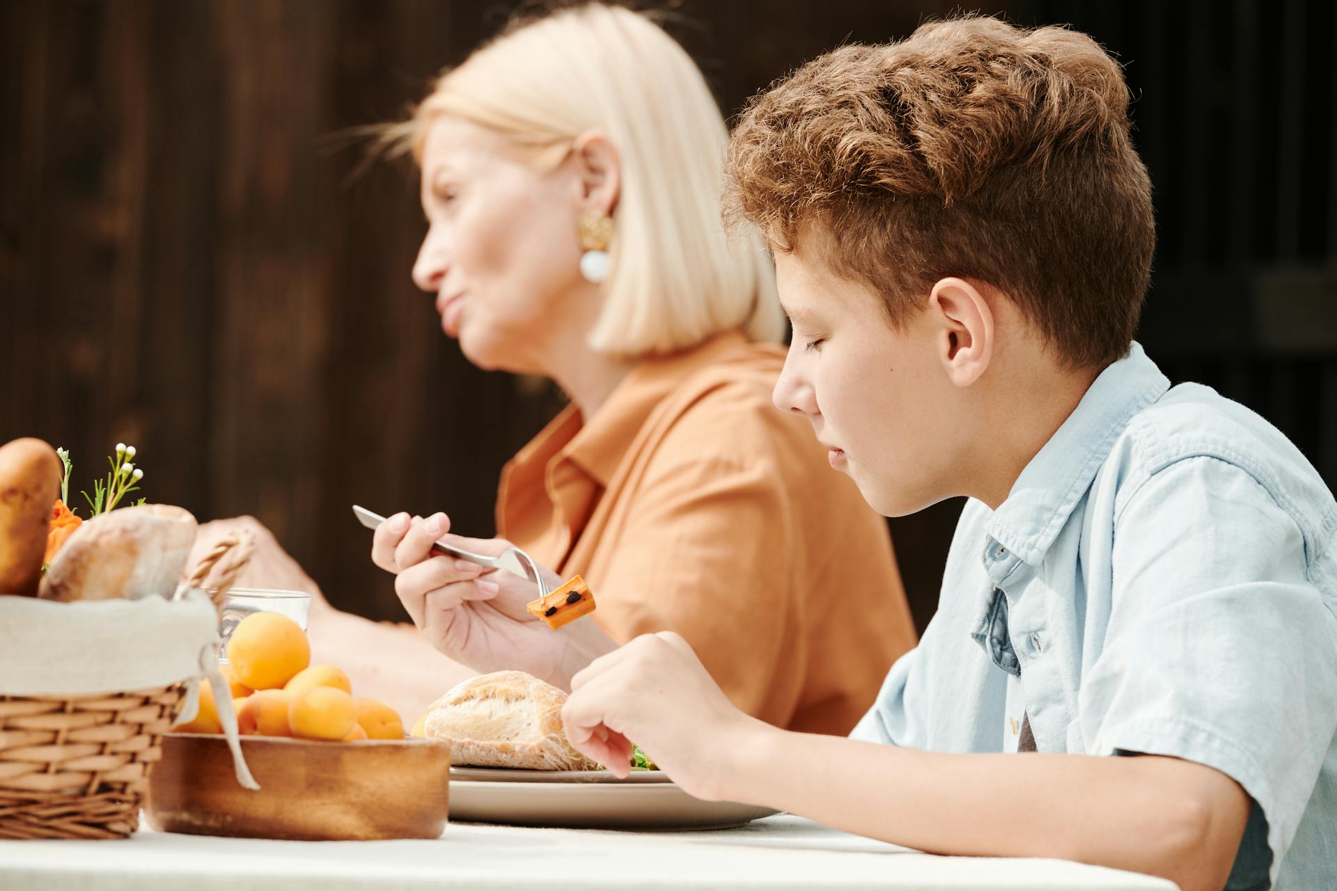 A Brunette Kid Eating Sausage