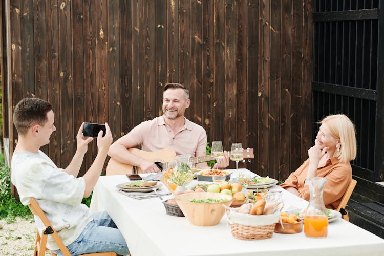 Family Sitting At Table With Food