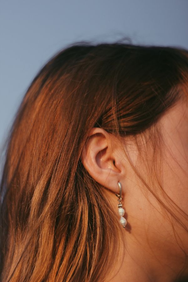 Elegant pearl earrings on a woman's ear